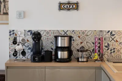 a kitchen counter with a coffee maker on top of it at La Villa L'Isle-St-Antoine piscine chauffée in LʼIsle-sur-la-Sorgue