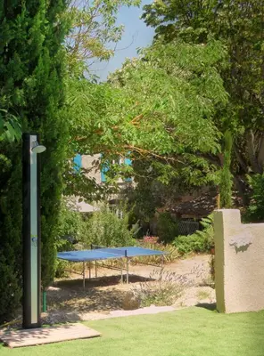 a blue bench in a park with trees and grass at Bastide De La Lézardière in Fontaine-de-Vaucluse