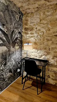 a desk with a lamp and a chair in a room at Suite dans le centre historique in Aix-en-Provence