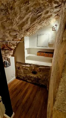 a room with a stone wall and a room with wood at Suite dans le centre historique in Aix-en-Provence