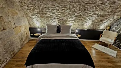 a bedroom with a bed and a stone wall at Suite dans le centre historique in Aix-en-Provence
