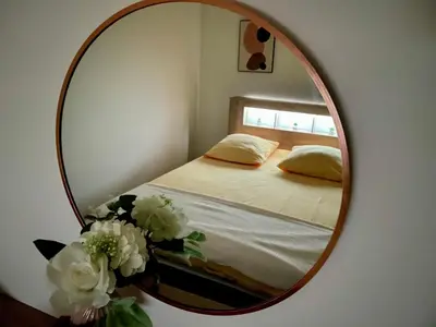 a mirror with a bed and flowers in a room at Chaleureux Appartement RDC 49 m2 avec Jardin in Aix-en-Provence