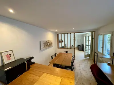 a living room with a table and a dining room at Chaleureux Appartement RDC 49 m2 avec Jardin in Aix-en-Provence