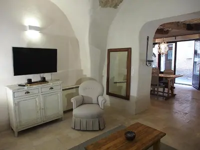 a living room with a tv and a chair at Le LOFT LOURMARIN in Lourmarin
