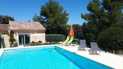 a swimming pool with two chairs and an umbrella at LS1-451 - Chambri in Orgon