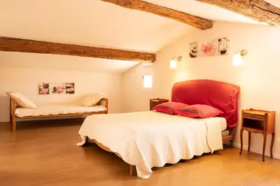 a bedroom with a bed and a chair in a room at La maison du bonheur in Pélissanne