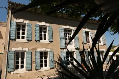 an old building with blue shuttered windows at La maison du bonheur in Pélissanne