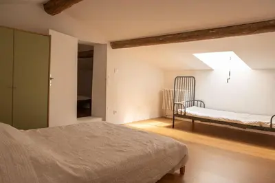 a bedroom with a bed and a bench in a room at La maison du bonheur in Pélissanne