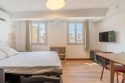 a bedroom with a bed and a table and a television at Studio climatisé plein centre 3eme étage in Aix-en-Provence