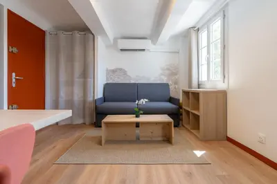 a living room with a blue couch and a coffee table at Studio climatisé plein centre 3eme étage in Aix-en-Provence