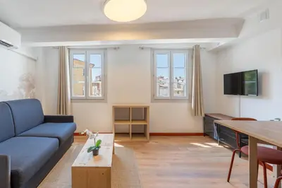 a living room with a blue couch and a table at Studio climatisé plein centre 3eme étage in Aix-en-Provence