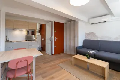 a living room with a table and a blue couch at Studio climatisé plein centre 3eme étage in Aix-en-Provence
