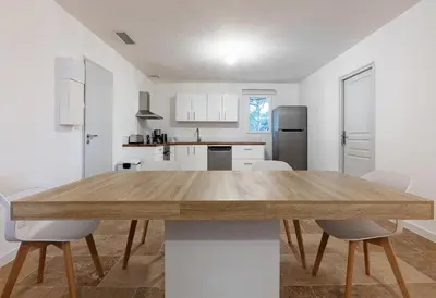 a kitchen and dining room with a wooden table and chairs at L' Aglandau Au coeur des oliviers en Provence in Pélissanne
