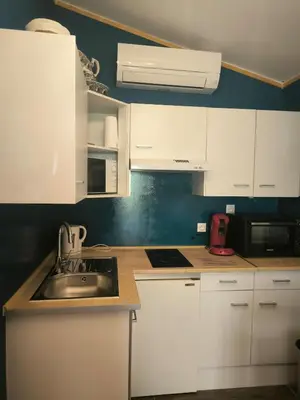 a kitchen with white cabinets and a sink at Logement 2 personnes in Morières-lès-Avignon