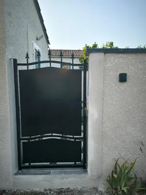 a black gate on the side of a building at Logement 2 personnes in Morières-lès-Avignon