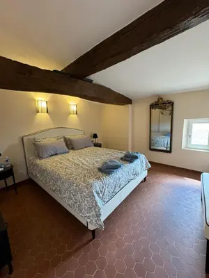 a bedroom with a large bed in a room at Atlantes de Saint Saturnin in Saint-Saturnin-les-Apt
