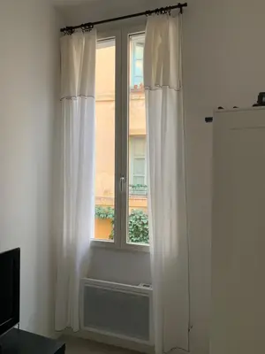 a window with white curtains in a room at Studio au cœur d Aix en Provence in Aix-en-Provence