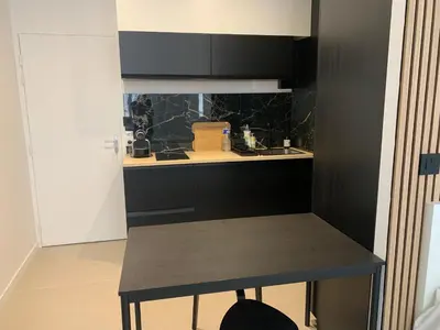 a kitchen with black cabinets and a table in it at Studio au cœur d Aix en Provence in Aix-en-Provence