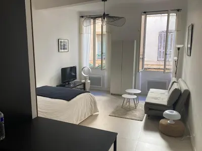 a bedroom with a bed and a tv and a chair at Studio au cœur d Aix en Provence in Aix-en-Provence