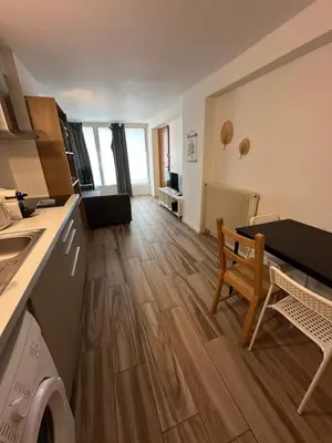 a kitchen and living room with a wooden floor at L'escapade aixoise in Aix-en-Provence
