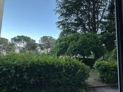 a window view of a garden with trees and bushes at L'escapade aixoise in Aix-en-Provence