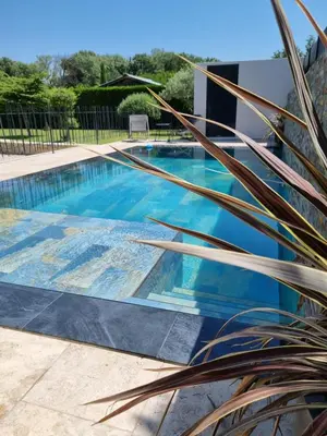 a swimming pool with blue water in a yard at Maison du Luberon in Maubec
