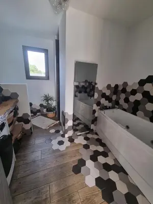 a bathroom with a bath tub and a tile floor at Maison du Luberon in Maubec