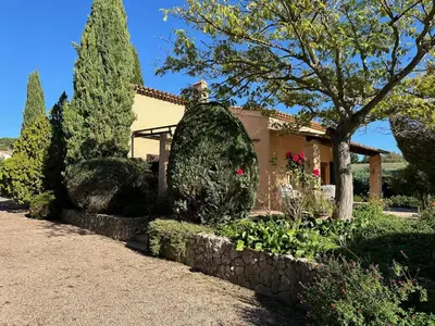 a garden in front of a house with trees and bushes at Villa provençale 4 chambres à Aix en Provence in Aix-en-Provence