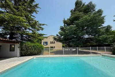 a swimming pool in front of a house at La Provençale - Piscine - Chambres climatisées in Aubignan