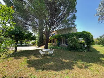 a table and chairs sitting in front of a house at La Provençale - Piscine - Chambres climatisées in Aubignan