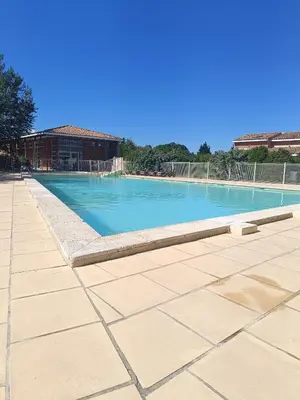 a large swimming pool with blue water at La Cigale d'Avignon in Saint-Saturnin-lès-Avignon