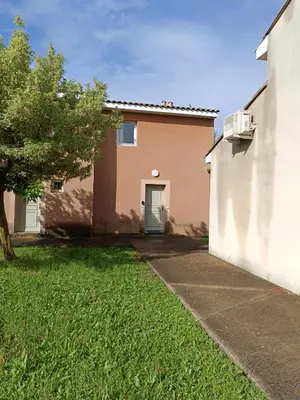 a house with a green door in a yard at La Cigale d'Avignon in Saint-Saturnin-lès-Avignon