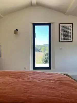 a bedroom with a large bed and a window at Grande Villa dans le Parc du Luberon in Beaumont-de-Pertuis