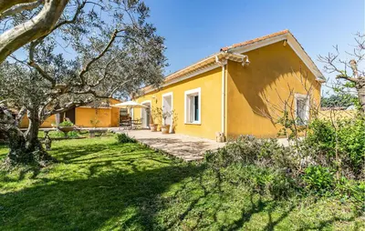 a yellow house with a yard in front of it at 2 Bedroom Amazing Home In Noves in Noves