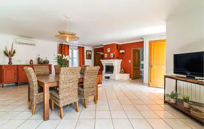 a dining room with a table and chairs and a television at 2 Bedroom Amazing Home In Noves in Noves