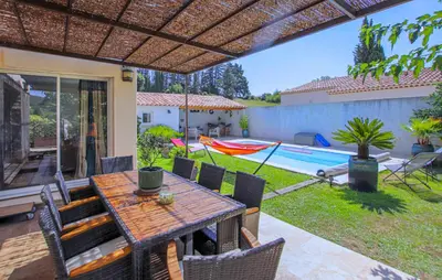 a patio with a table and chairs and a pool at Villa Contemporaine Provençale in Mormoiron
