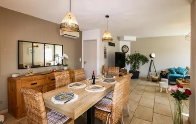 a dining room and living room with a table and chairs at Villa Contemporaine Provençale in Mormoiron