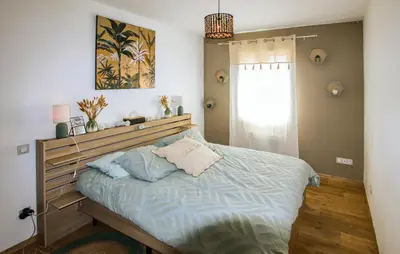 a bedroom with a large bed with blue pillows at Villa Contemporaine Provençale in Mormoiron