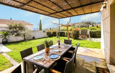 a wooden table and chairs on a patio at Villa Contemporaine Provençale in Mormoiron