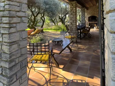 a patio with chairs and a table and a stone wall at Gite Lucie in Carpentras