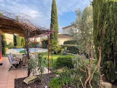 a patio with a table and chairs in a garden at Villa Nicole avec piscine & jardin privés, parking dans le cœur du Luberon, proche Gordes, Roussillon, Goult, Bonnieux in Oppède