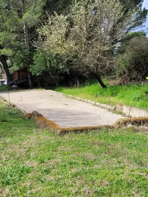 a concrete walkway in a park with trees and grass at Gîte Chrysalide du Luberon in Cheval-Blanc