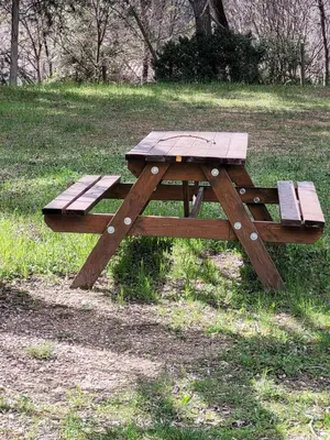 a wooden picnic table sitting in a field at Gîte Chrysalide du Luberon in Cheval-Blanc