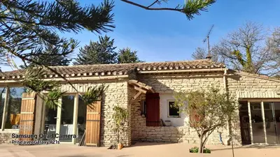 a small stone house with a tree in front of it at Le MAS DES VERGIERS in Murs