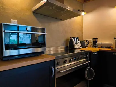 a kitchen with a stove and a microwave at Appartement Superbe 2 personnes Coeur de ville l'Isle sur Sorgue in LʼIsle-sur-la-Sorgue