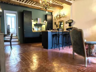 a kitchen with a counter and a bar with chairs at Appartement Superbe 2 personnes Coeur de ville l'Isle sur Sorgue in LʼIsle-sur-la-Sorgue