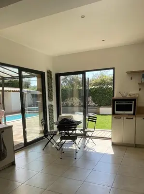 a kitchen with a table and chairs in a room at Fermer in Malemort-du-Comtat