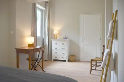 a bedroom with a bed and a desk and a window at Les Lavandières in Velleron