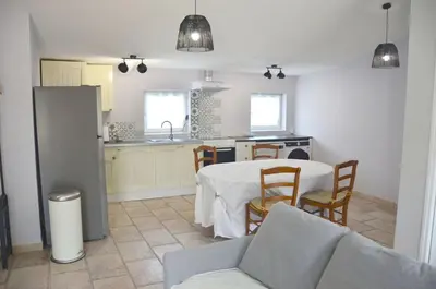 a kitchen and dining room with a table and chairs at Les Lavandières in Velleron