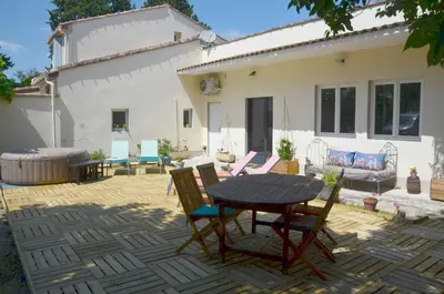 a patio with a table and chairs in front of a house at Les Lavandières in Velleron